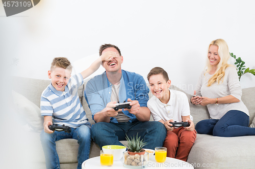 Image of Happy young family playing videogame On TV.