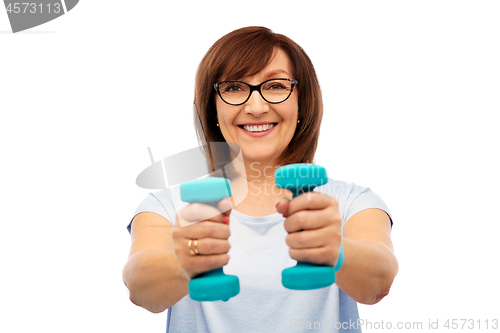 Image of smiling senior woman with dumbbells exercising