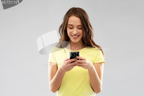 Image of young woman or teenage girl using smartphone