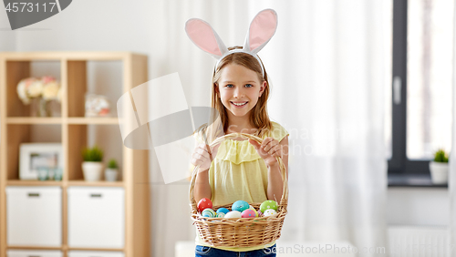 Image of happy girl with colored easter eggs at home