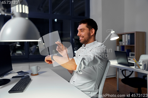 Image of businessman using smart watch at nigh office