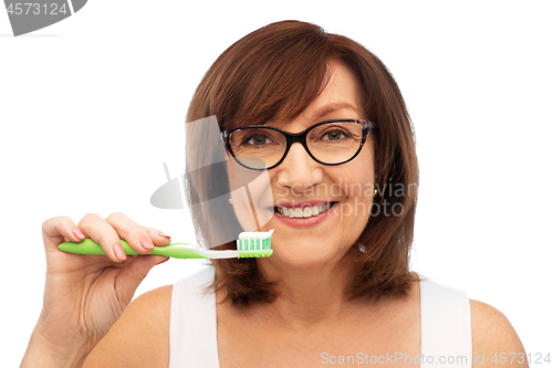 Image of senior woman with toothbrush brushing her teeth