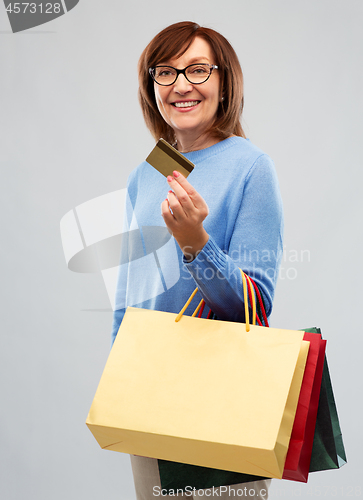 Image of senior woman with shopping bags and credit card