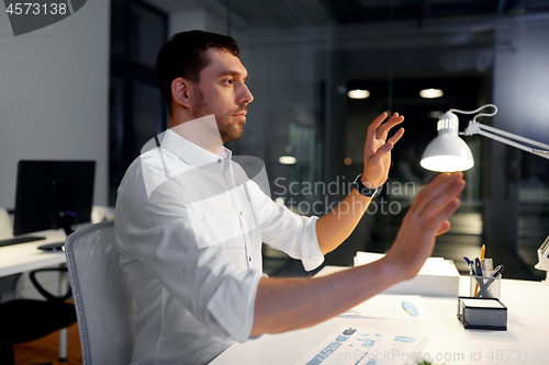 Image of businessman using gestures at night office