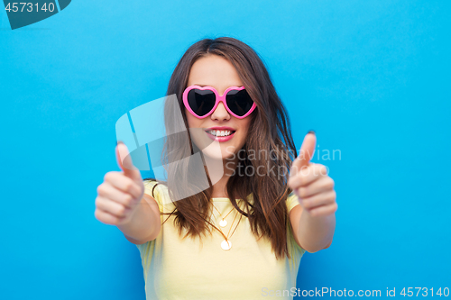 Image of teen girl in heart-shaped shades shows thumbs up