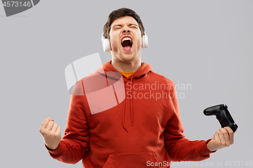 Image of man or or gamer with gamepad winning in video game