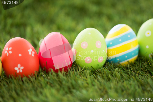 Image of row of colored easter eggs on artificial grass