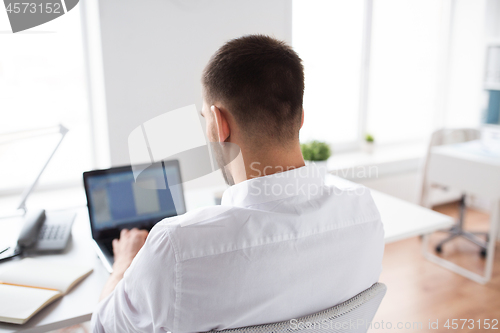 Image of close up of businessman typing on laptop at office