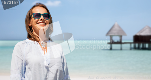 Image of happy smiling woman in sunglasses over beach