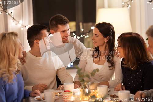 Image of happy family having tea party at home