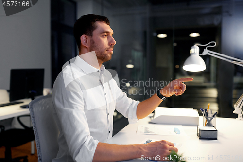 Image of businessman using gestures at night office