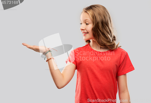 Image of smiling teenage girl holding empty hand