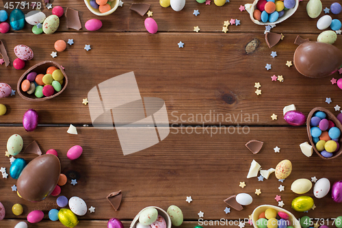 Image of chocolate eggs and candy drops on wooden table