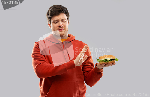Image of young man refusing from hamburger