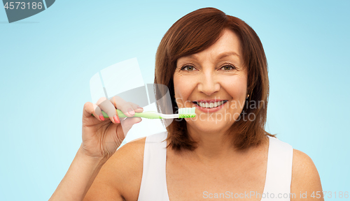 Image of senior woman with toothbrush brushing her teeth