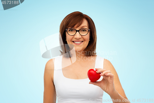 Image of portrait of smiling senior woman holding red heart