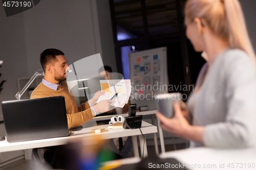 Image of business team with papers working late at office