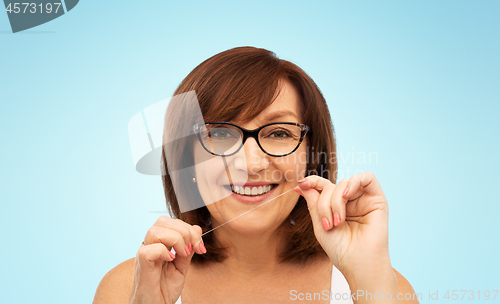 Image of senior woman cleaning her teeth by dental floss