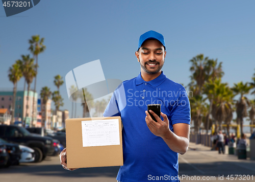 Image of indian delivery man with smartphone and parcel box