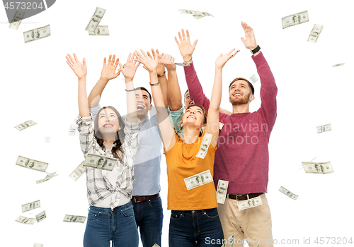 Image of happy friends picking money falling from up above