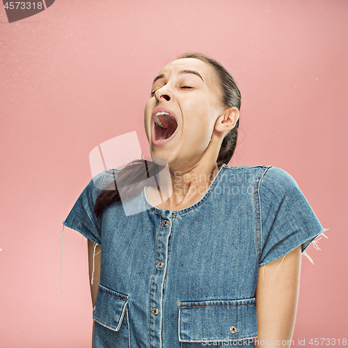Image of Young woman sneezing, studio portrait