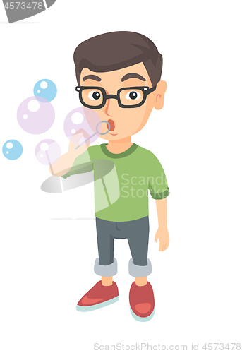 Image of Little caucasian boy blowing soap bubbles.