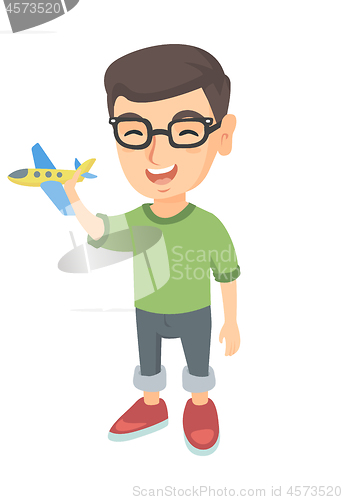 Image of Caucasian cheerful boy playing with a toy airplane