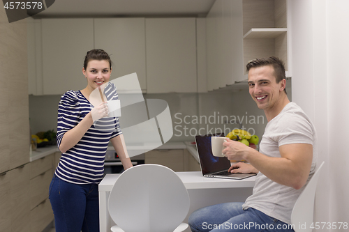 Image of couple with laptop computer enjoying morning