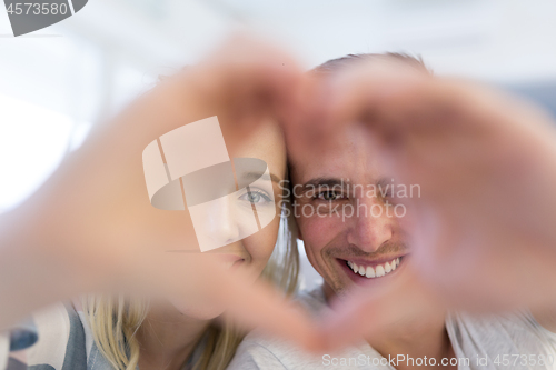 Image of couple making heart with hands