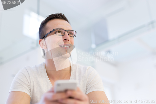 Image of young man using a mobile phone  at home