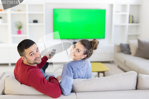 Image of Young couple on the sofa watching television