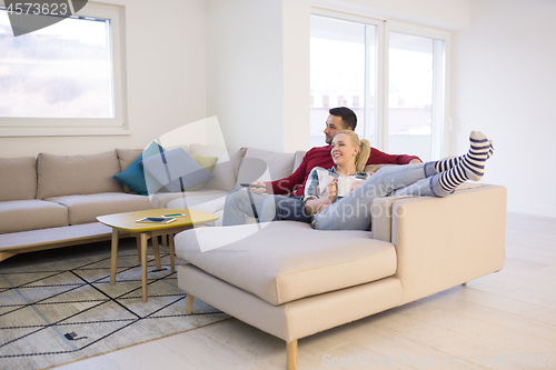 Image of Young couple on the sofa watching television