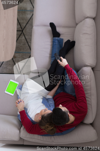 Image of Young couple on the sofa watching television top view