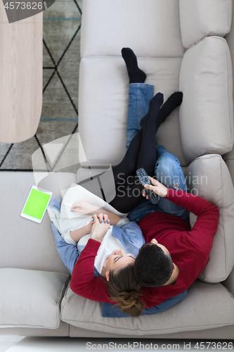 Image of Young couple on the sofa watching television top view