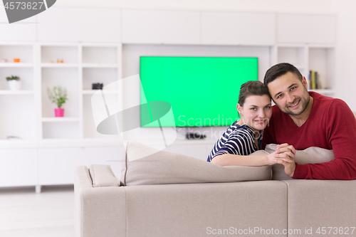 Image of couple hugging and relaxing on sofa