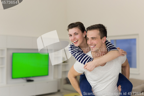 Image of handsome man piggybacking his girlfriend