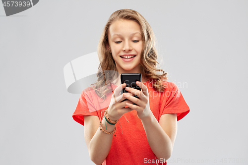 Image of smiling teenage girl using smartphone