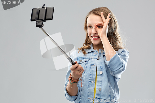Image of teenage girl taking selfie by smartphone