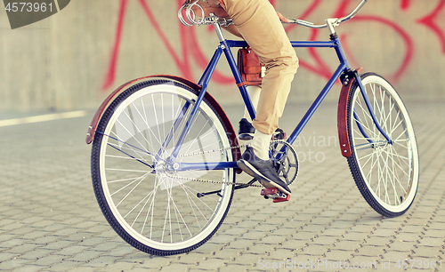 Image of close up of hipster man riding fixed gear bike