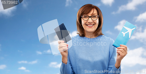 Image of senior woman with passport and airplane ticket