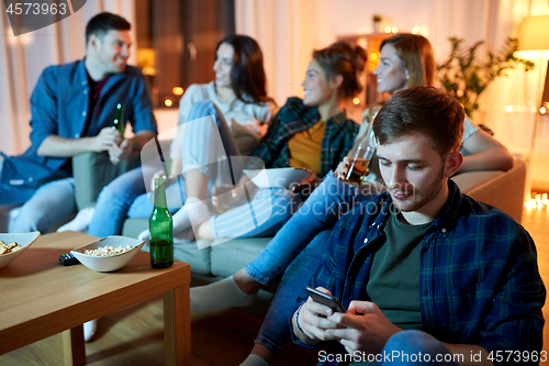 Image of man with smartphone at home party