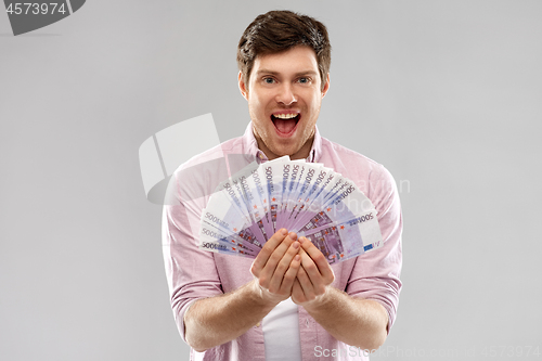 Image of happy young man with fan of euro money