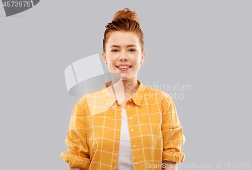 Image of smiling red haired teenage girl in checkered shirt