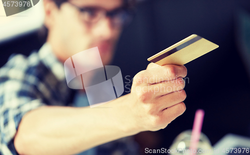 Image of man paying with credit card at cafe