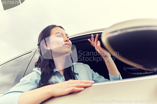 Image of happy young woman driving in car