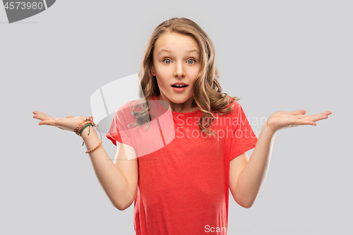 Image of wondering teenage girl in red t-shirt shrugging