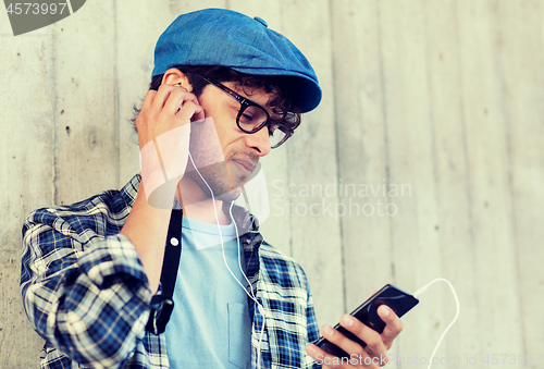 Image of man with earphones and smartphone listening music