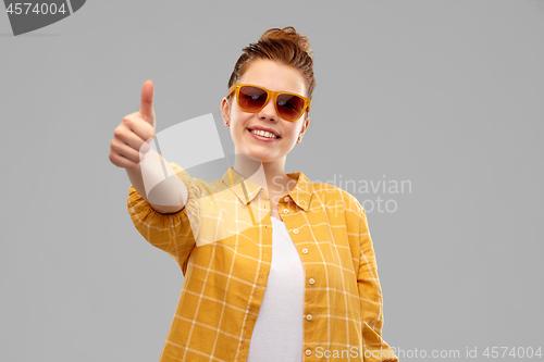 Image of happy teenage girl in sunglasses showing thumbs up