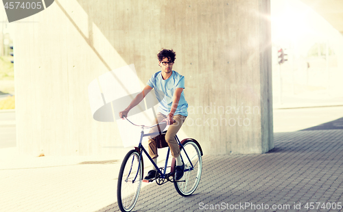 Image of young hipster man riding fixed gear bike