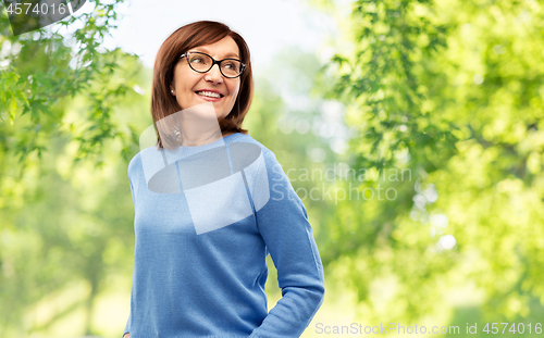 Image of senior woman in glasses over natural background